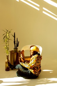 a person sitting in a chair with a cactus